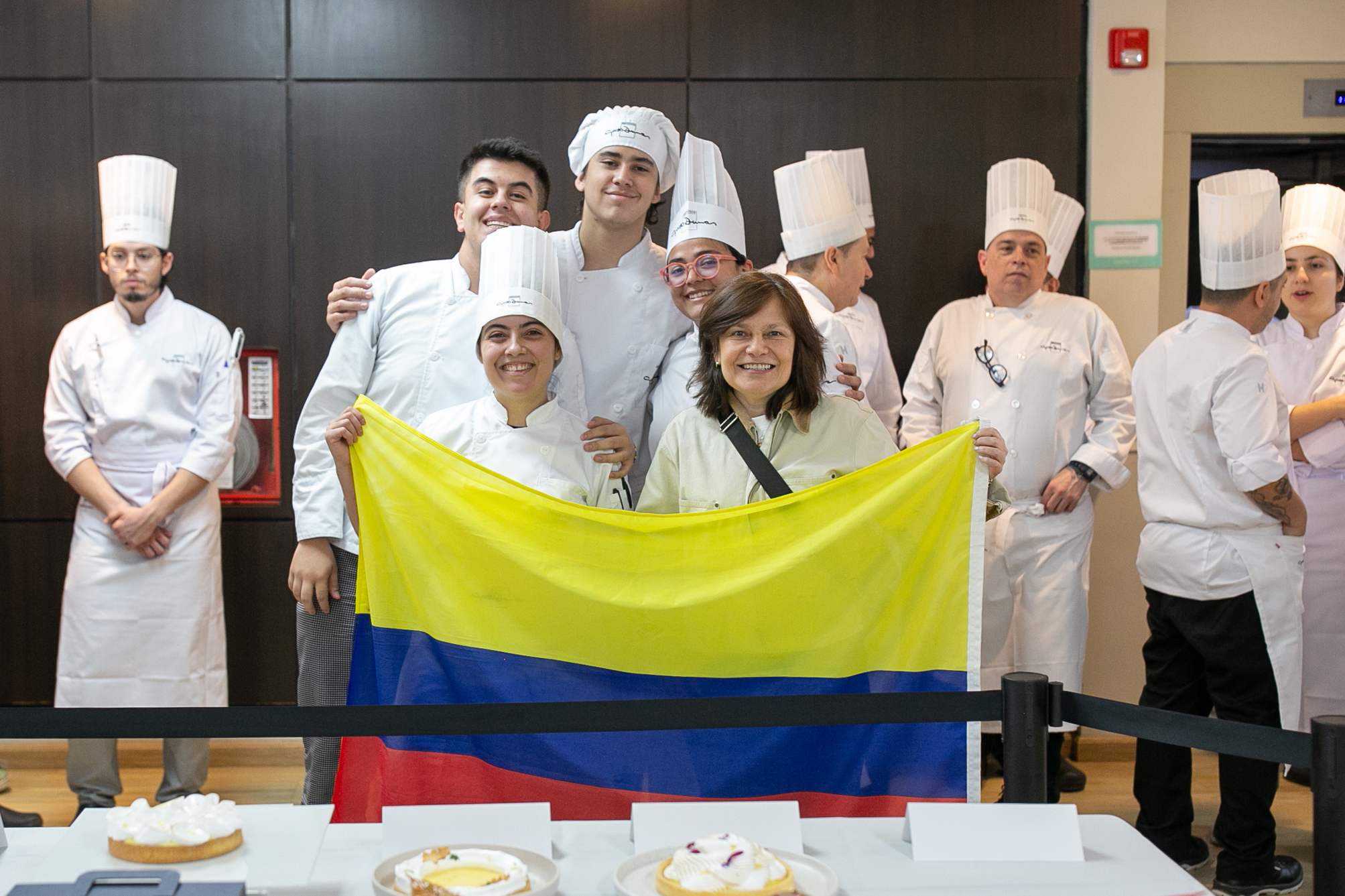 Delegación de estudiantes de Colombia sosteniendo su bandera en el Torneo Intersedes Gato Dumas 2026.